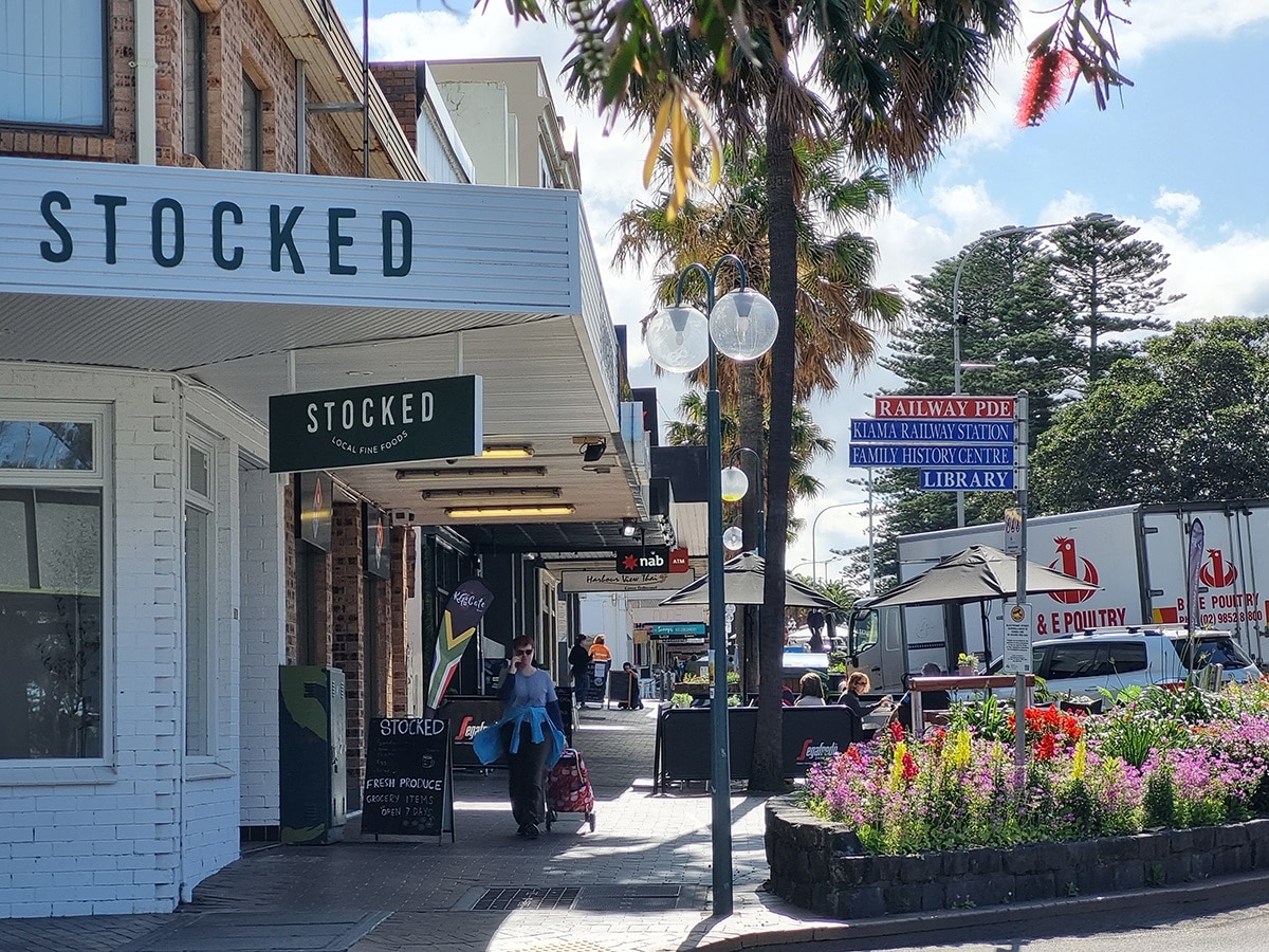 A rua principal de uma cidade costeira com dezenas de empresas locais e placas de rua.