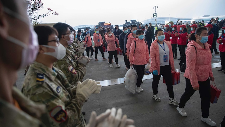 Departing medical workers enter Wuhan's airport after completing their duties in the city.