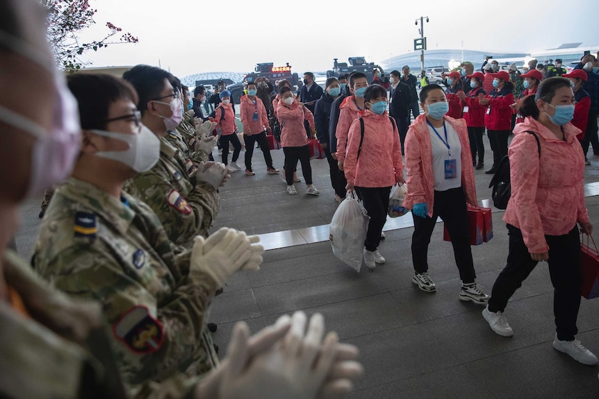 Departing medical workers enter Wuhan's airport after completing their duties in the city.