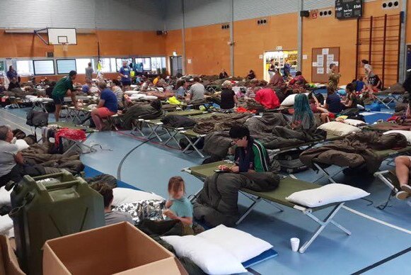 People take shelters at evacuation centre set up at a sports hall in flooded Townsville.