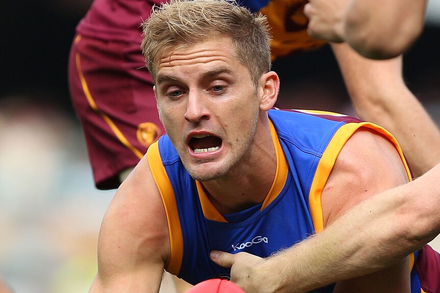 Brisbane's Joel Patfull handballs against Port Adelaide in July 2011.