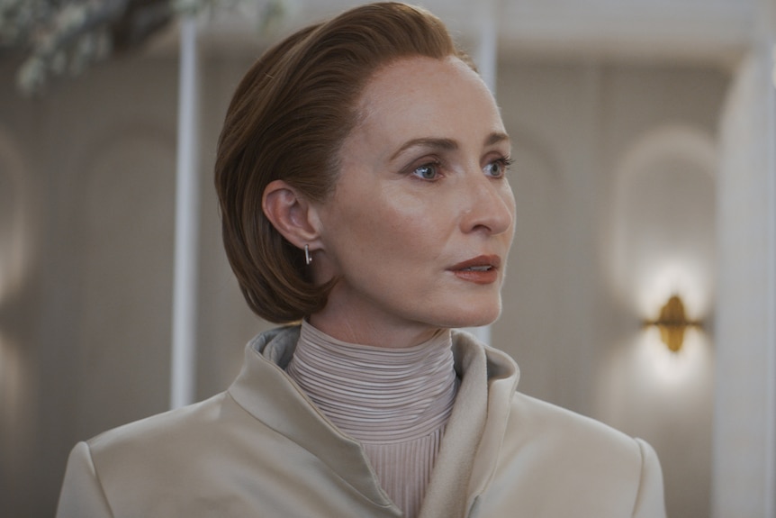 actor genevieve o'reilly in character as mon mothma in andor wearing a beige coloured costume, her hair is slicked back 