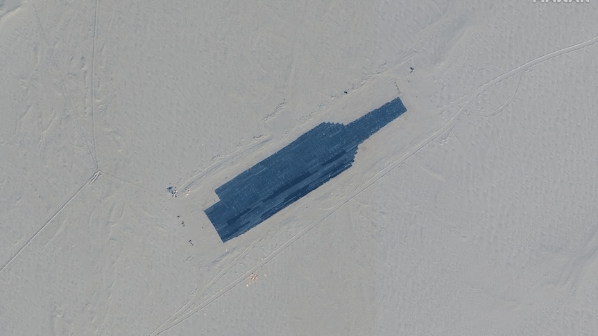 A close up satellite view of a navy carrier-shaped area in the Chinese desert