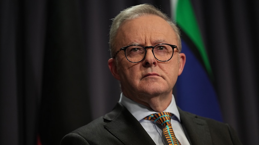 Anthony Albanese, wearing a suit and glasses, looking serious.