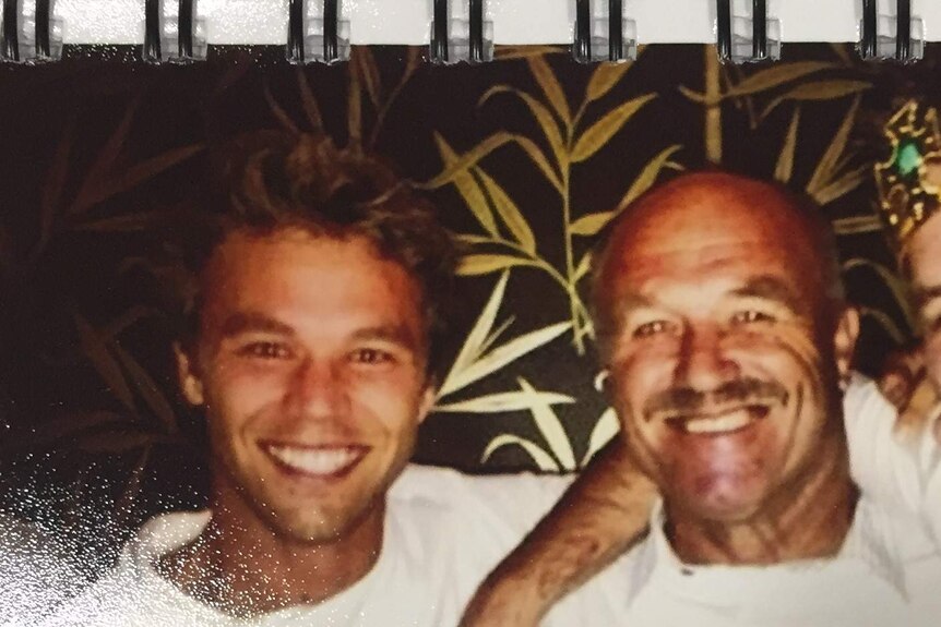 Lincoln Lewis and his father Wally Lewis smile for the camera at a party.