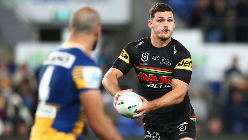 Rugby league player running the ball with opposition player in front of him