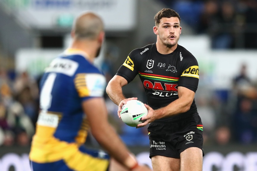 Rugby league player running the ball with opposition player in front of him