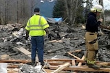 Emergency services personnel work at the site of the massive mudslide.