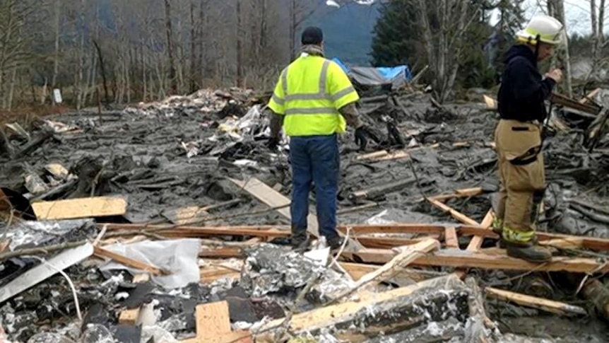 Emergency services personnel work at the site of the massive mudslide.