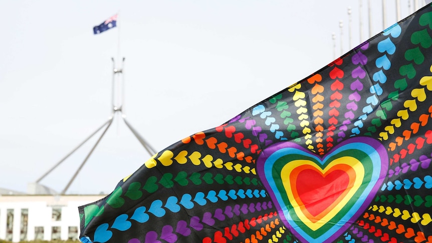 Rainbow heart flag flies in front of Parliament House