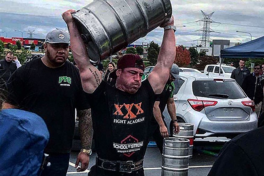 A man carries a beer keg above his head