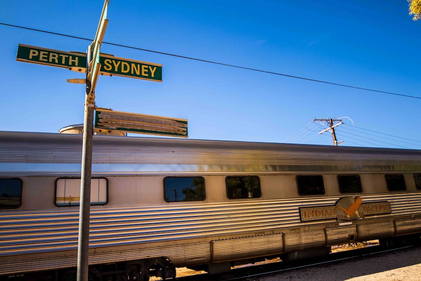 A street sign pointing out directions at a railway station