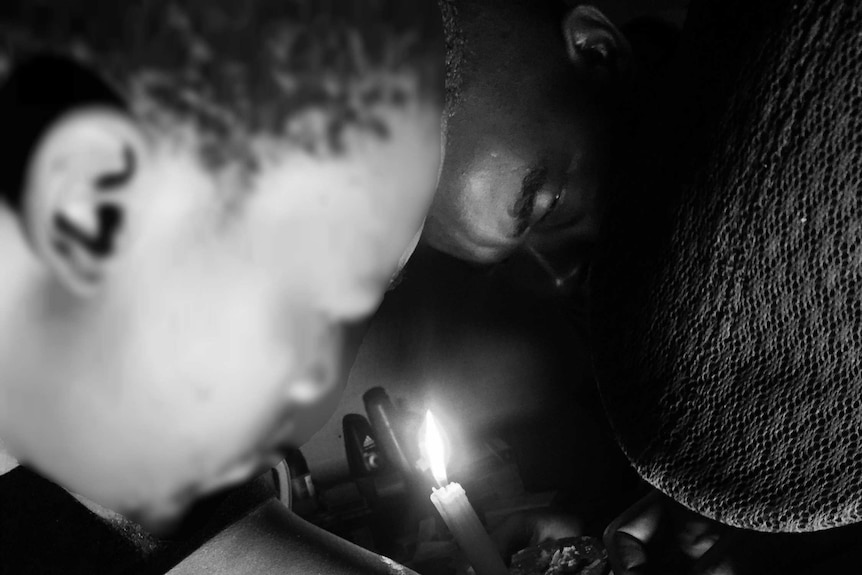 A man watches as blood is injected into his arm.