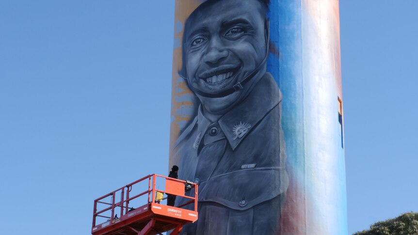 painted water tower with portrait of indigenous soldier smiling