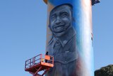 painted water tower with portrait of indigenous soldier smiling