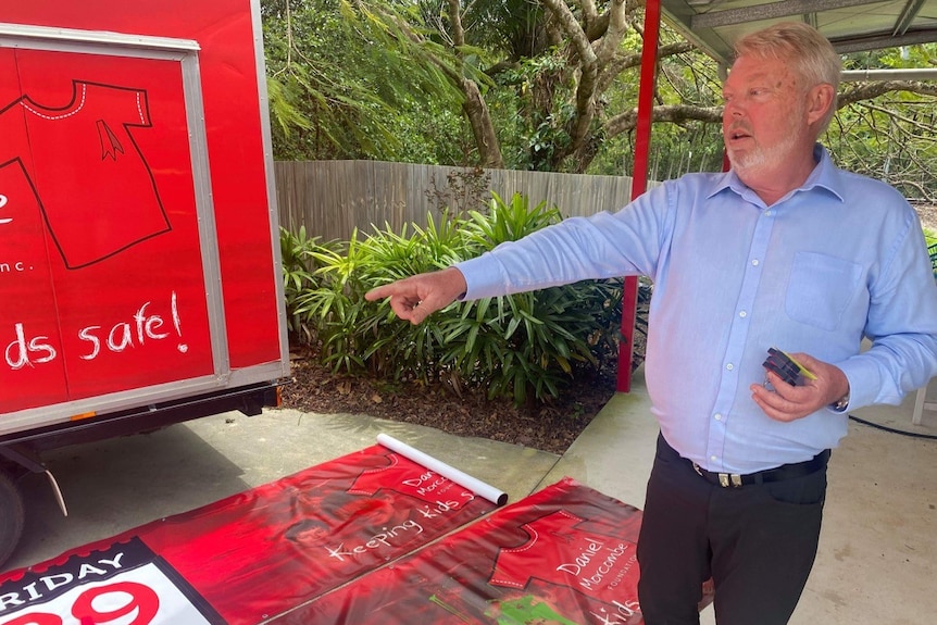 Daniel Morcombe stands in front of posters defaced by a vandal