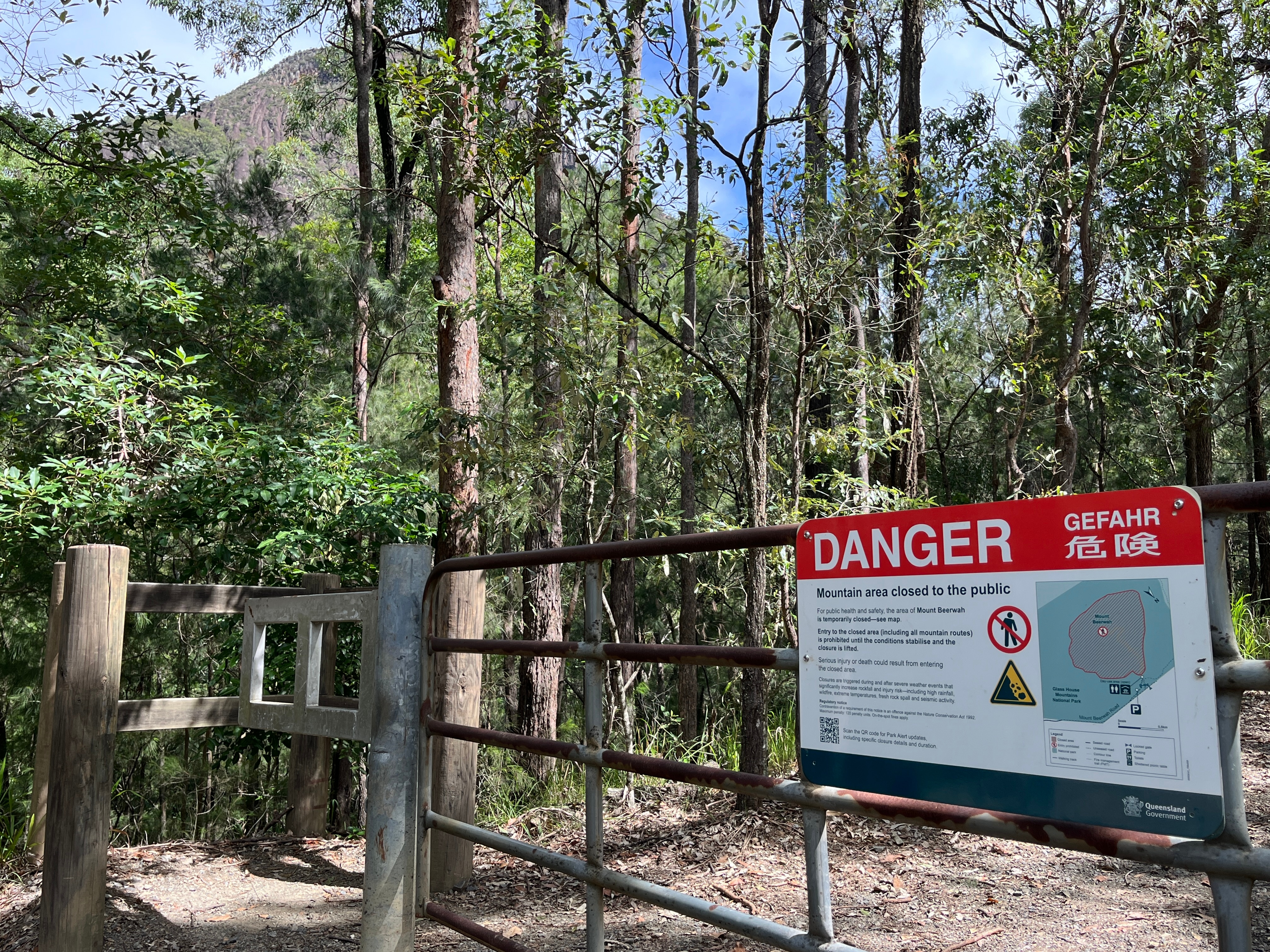 Bush and mountain with danger sign.