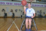A man in a wheelchair spinning a basketball on his finger