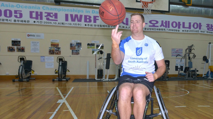 A man in a wheelchair spinning a basketball on his finger