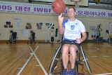 A man in a wheelchair spinning a basketball on his finger