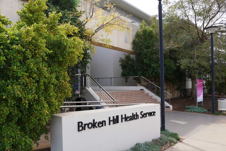 Un plan du sentier des escaliers menant à une entrée et un panneau indiquant le service de santé de Broken Hill.