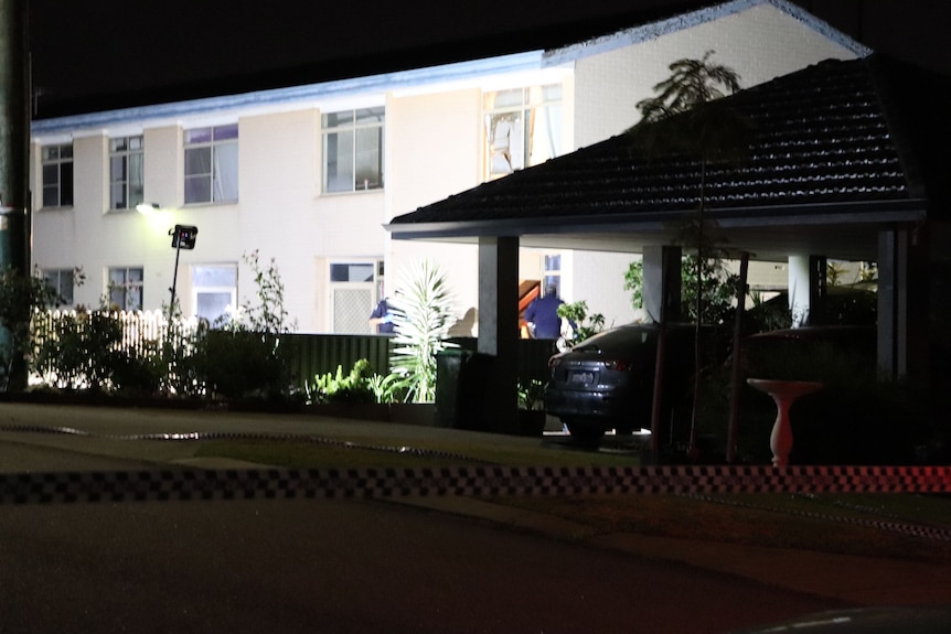 White double-storey unit complex with a smashed window on upper floor 