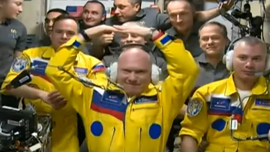 Cosmonauts Sergei Korsakov, Оleg Аrtemiev, and Denis Мatveev pose among other participants of expedition to the ISS