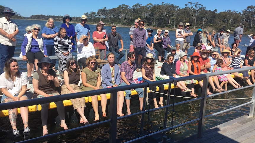 group of people sitting and standing on jetty on Gippsland Lakes