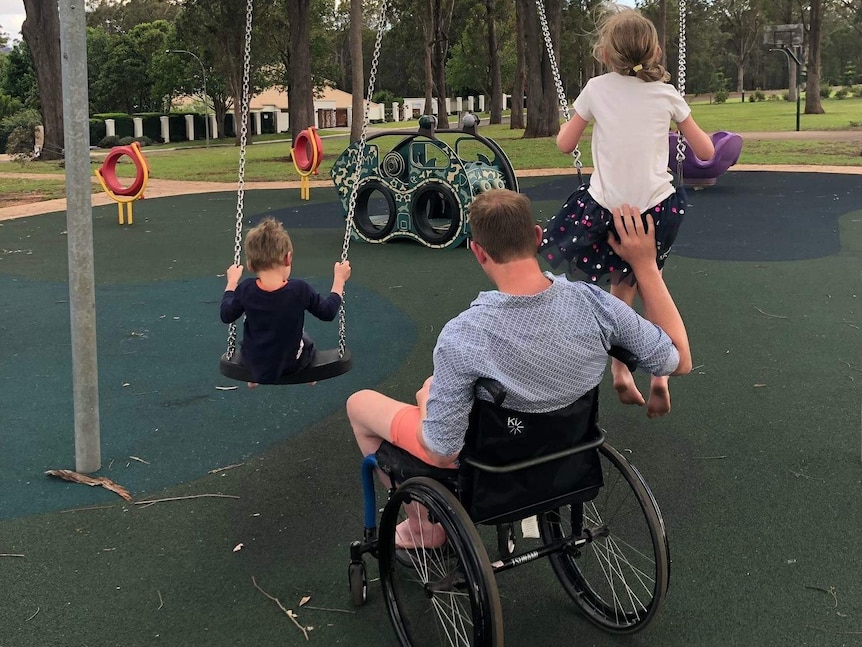 Josh Marshall playing with his two young children in a Toowoomba park.