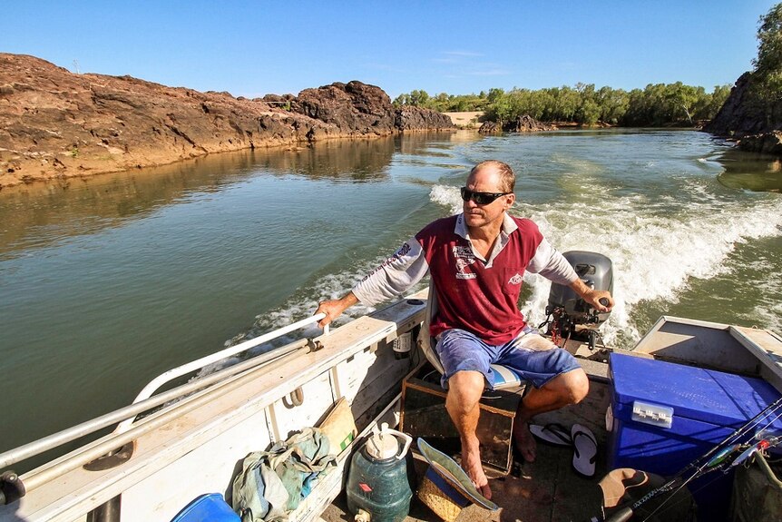 Kununurra fisherman Paul Stewart manning his boat on the Ord River.