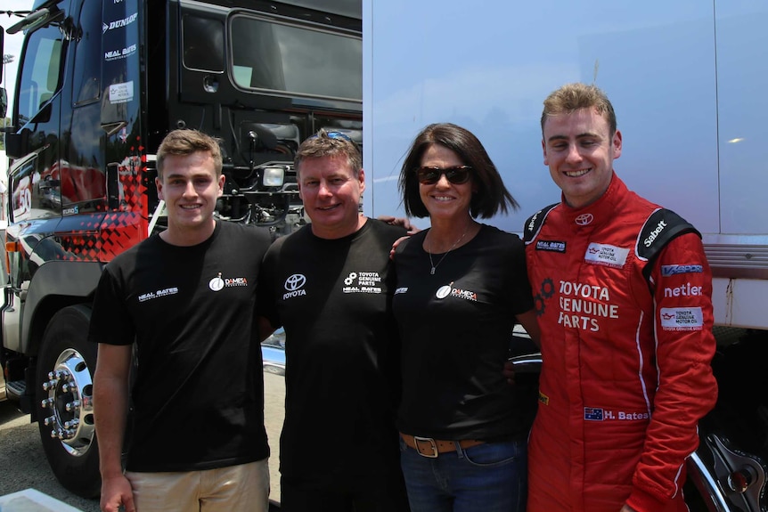 Four people standing in front of a truck.