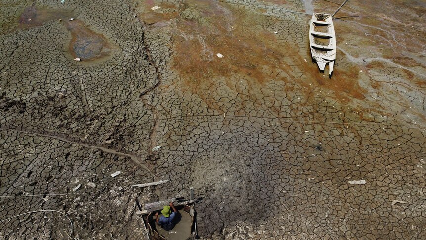  Isac Cicero Rodrigues digs into the dry bed of Puraquequara lake to obtain water amid a severe drought,