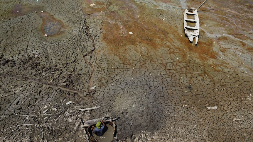  Isac Cicero Rodrigues digs into the dry bed of Puraquequara lake to obtain water amid a severe drought,