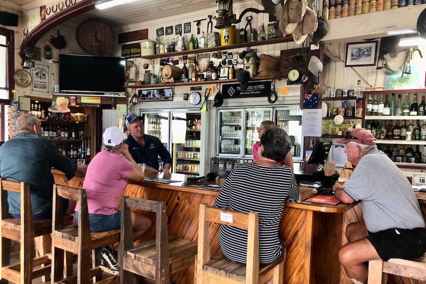 People sitting around a bar with memorabilia up on the wall