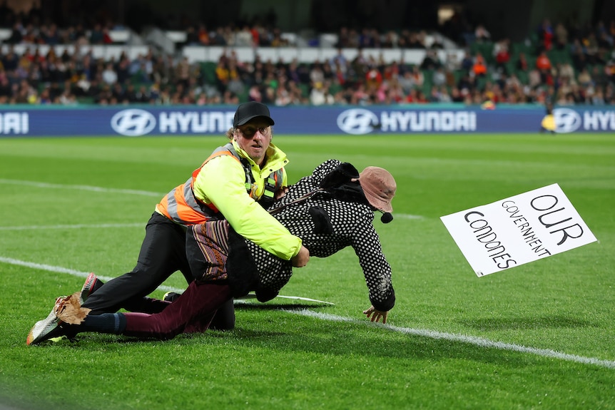 A pitch invader is tackled