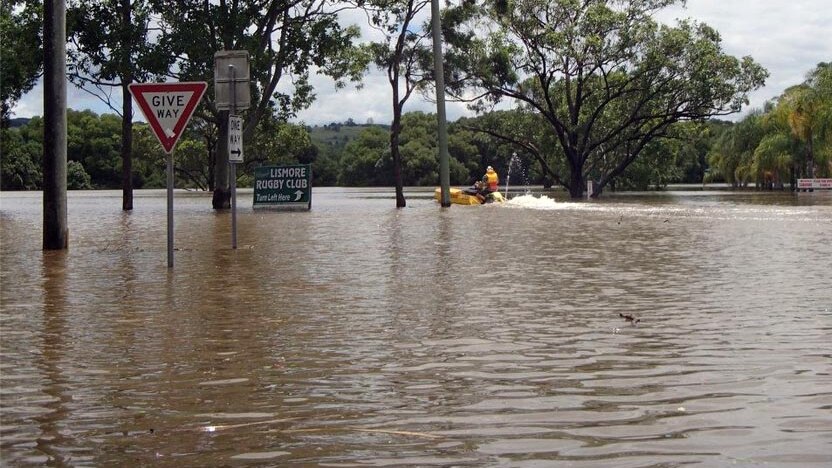 A boat makes its way through floodwaters in Lismore.