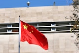 A Chinese flag flutters in wind before the Chinese Consulate building in East Perth on a sunny day.