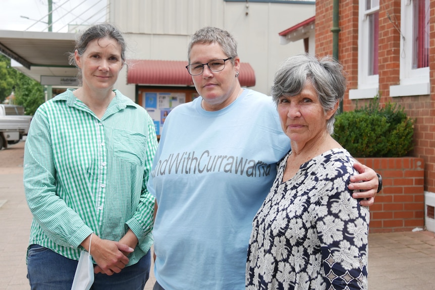 Three women standing together with angry facing in a rural town