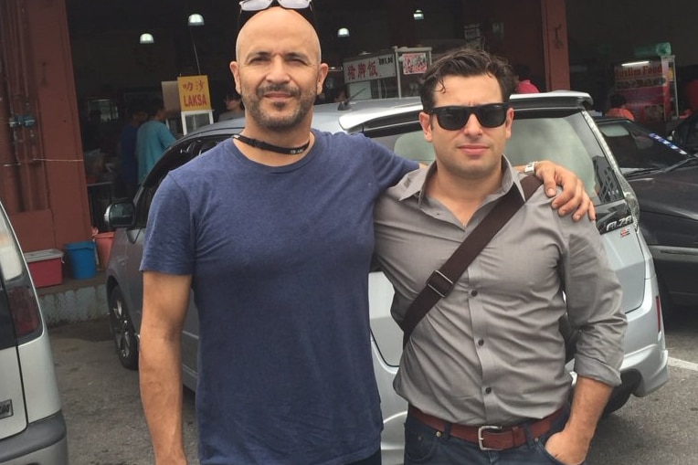 Four Corners cameraman Louie Eroglu and reporter Linton Besser stand outside a store.