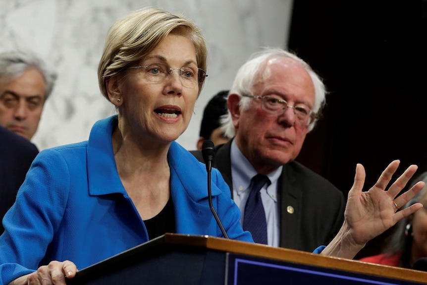 Elizabeth Warren speaks into a microphone.