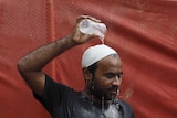 Man pours water on his head to cool off from the heat in Pakistan