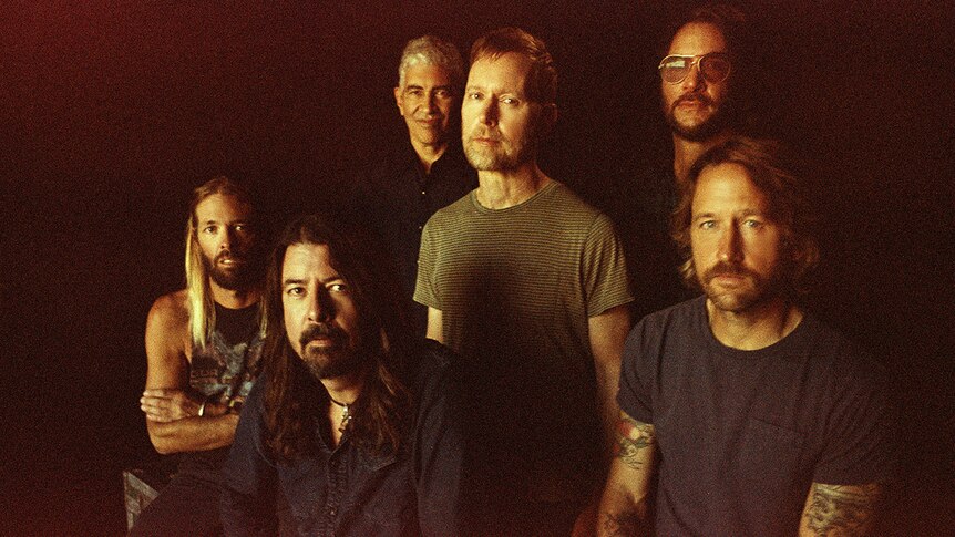 Six members of Foo Fighters stare into the camera in a slightly blurry vintage looking photo