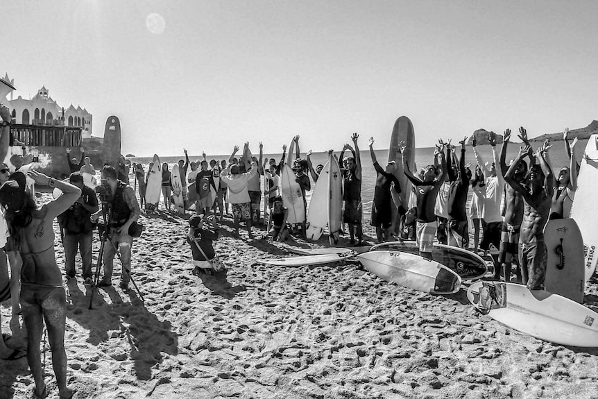 Surfers gather in a circle on the beach before the paddle-out ceremony in honour of Dean Lucas and Adam Coleman