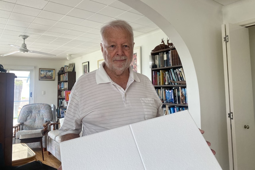 A man with white plastic tiles in his living room