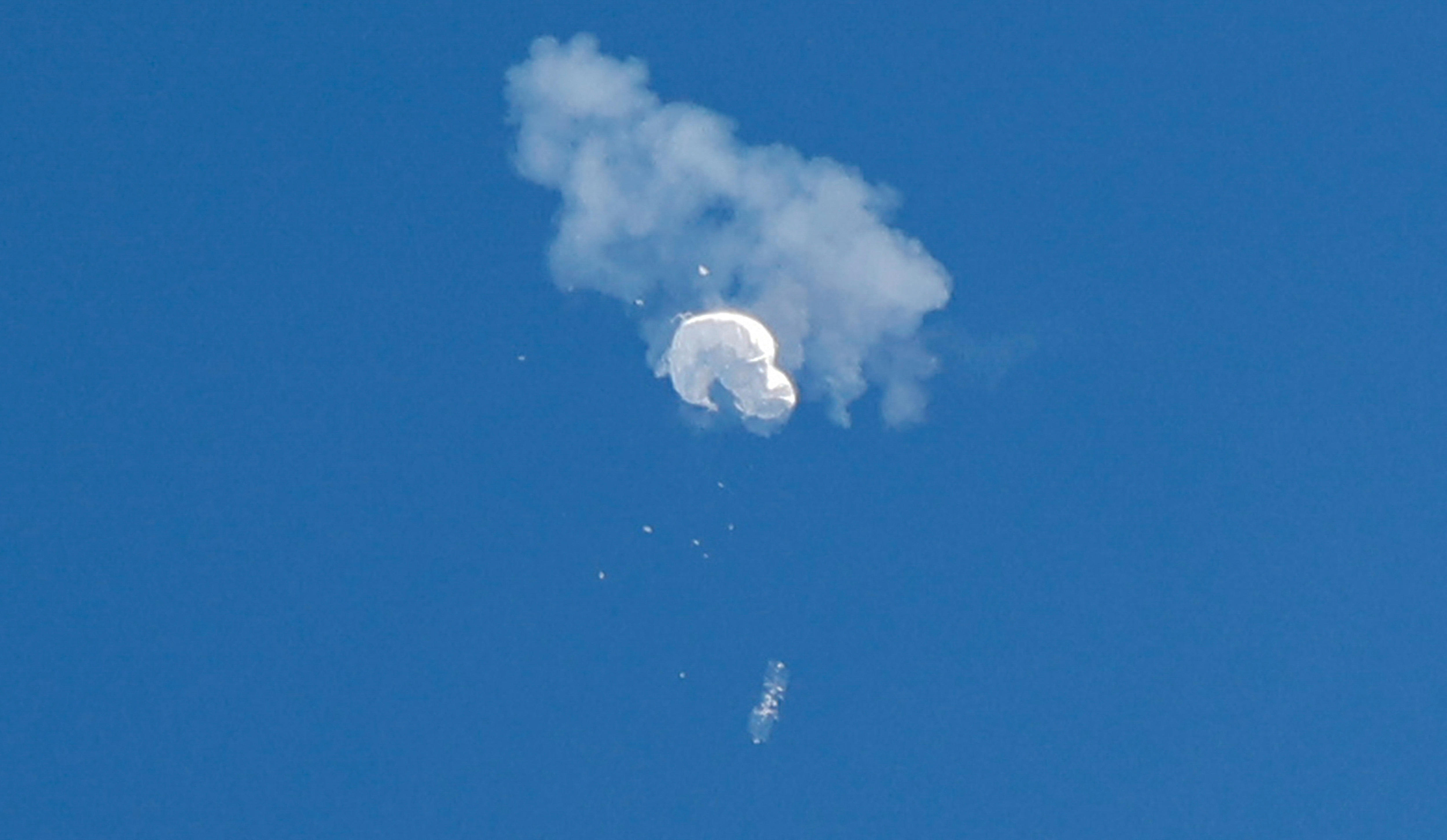 白色气球从天而降时，一缕烟雾和碎屑围绕着它。
