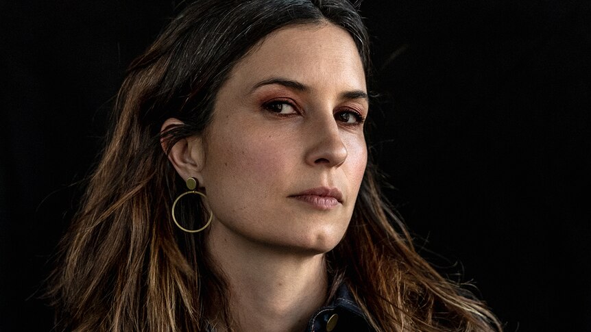 Close up photo of Missy Higgins. She wears a gold hoop earring and has long hair.