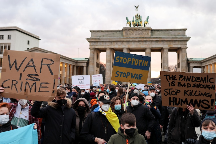 Demonstrators carry banners during an anti-war protest at Brandenburg Gate.