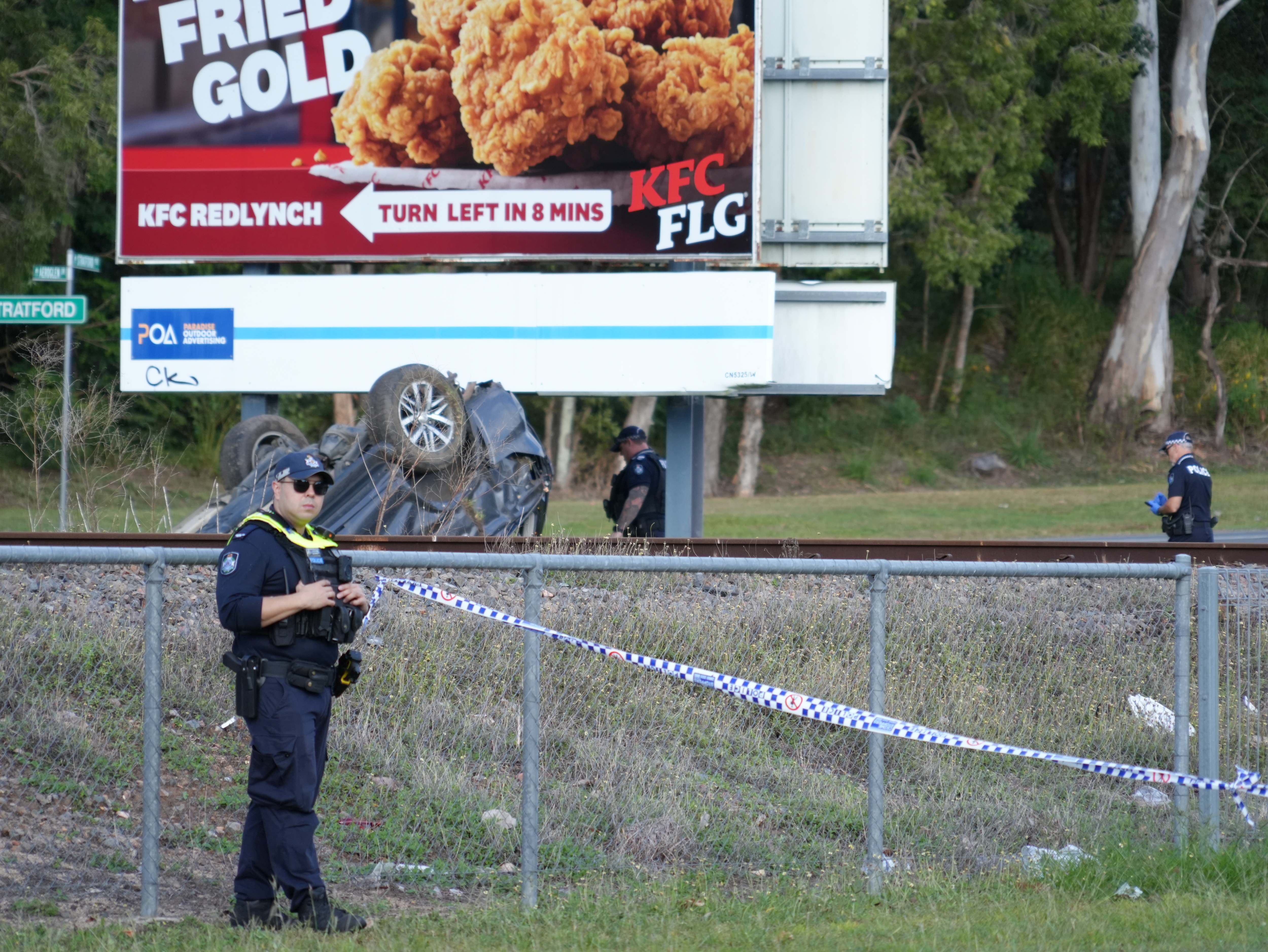 A car on its roof beside a road in Cairns.
