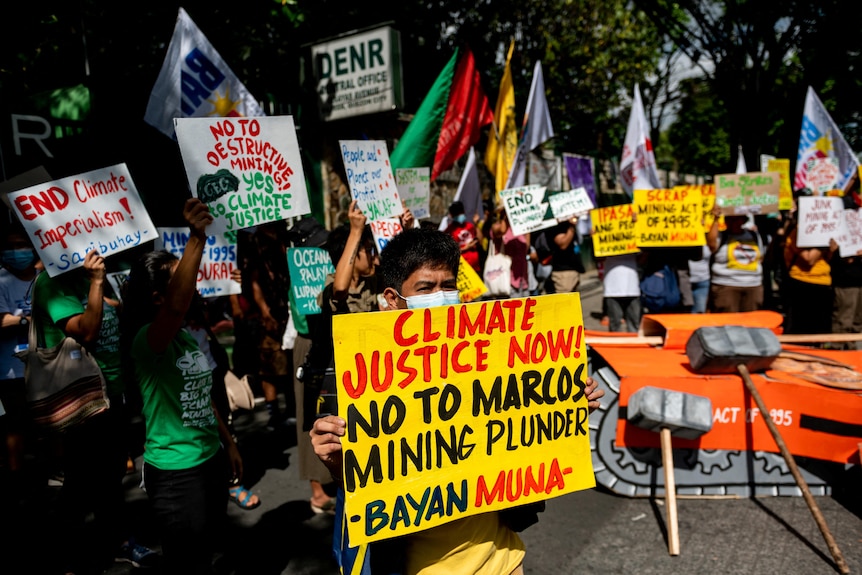Activists hold up placards about climate justice