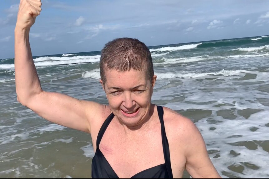 Woman with short hair emerging from the sea